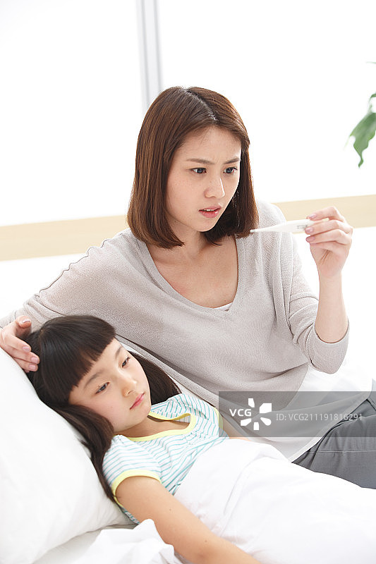 母亲正在为女儿测量体温图片素材
