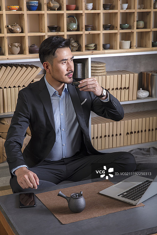 商务男士在茶馆用笔记本工作图片素材