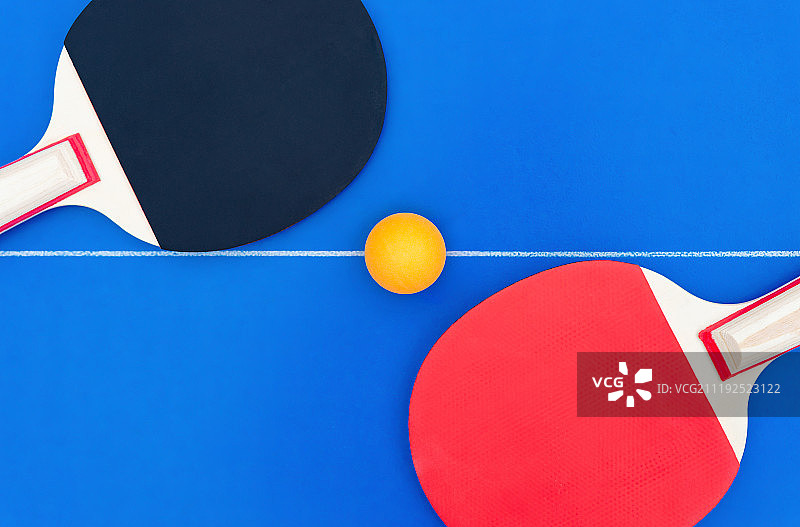 摆放于球台中线上的一对乒乓球拍和乒乓球图片素材
