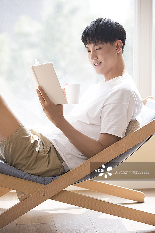年轻男子在家看书图片素材