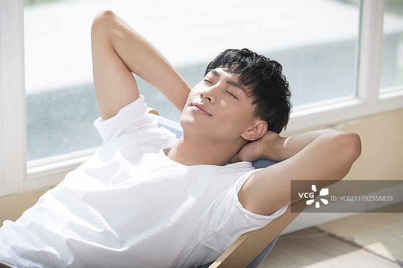 年轻男子在躺椅上休息图片素材