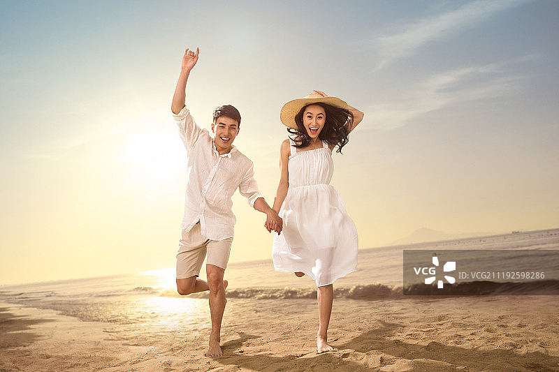 青年情侣在沙滩上玩耍图片素材