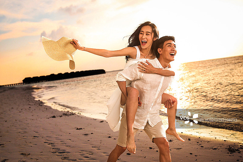 青年情侣在沙滩上玩耍图片素材