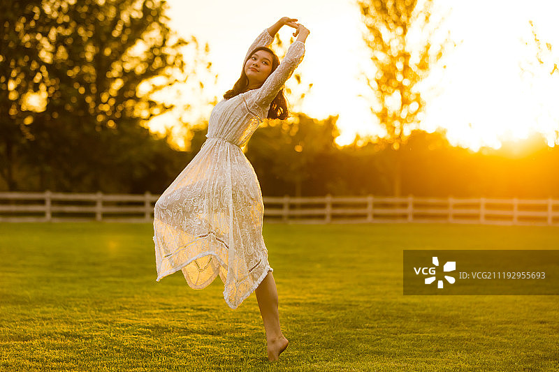 青年女人在草地上跳舞图片素材