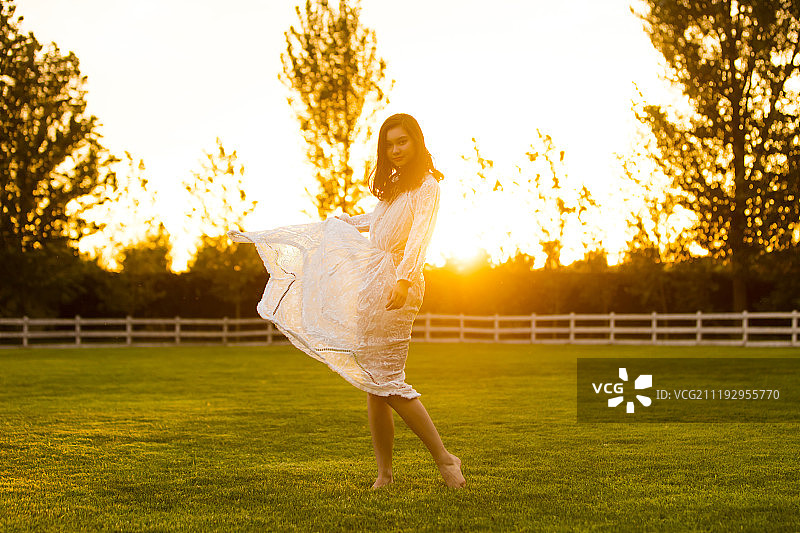青年女人在草地上跳舞图片素材