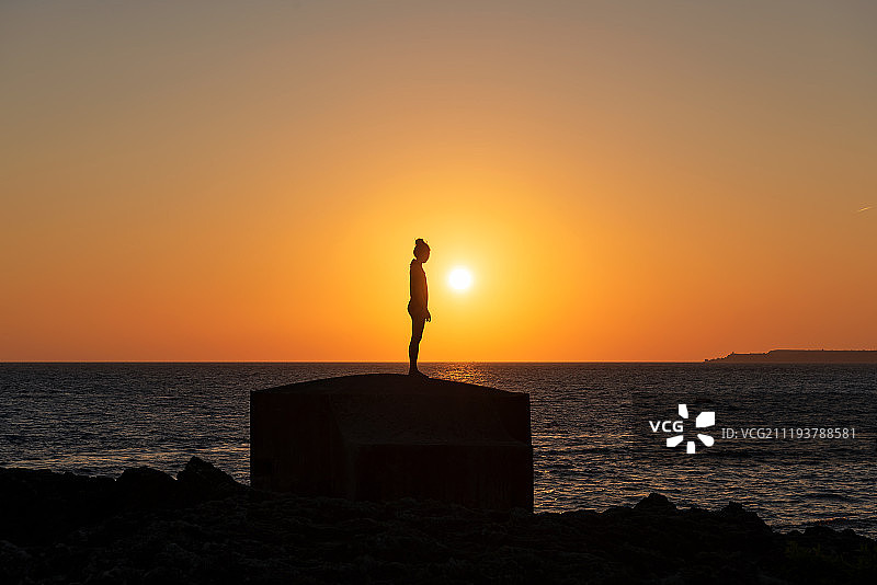 日落时分站立在海边的女人剪影图片素材