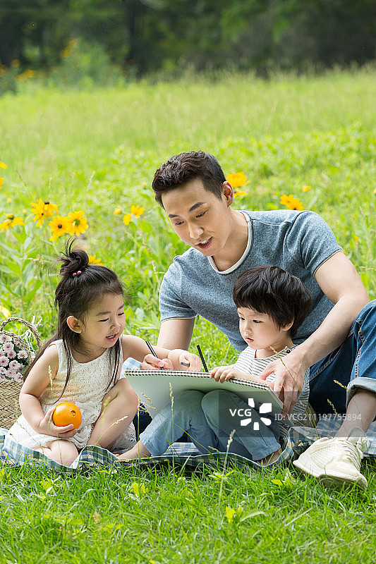 爸爸和两个孩子在户外画画图片素材