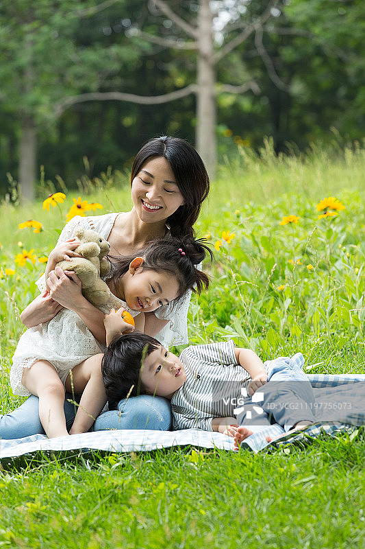 妈妈和两个孩子在户外郊游嬉戏图片素材