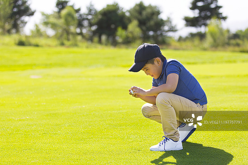 男孩拿着高尔夫球图片素材