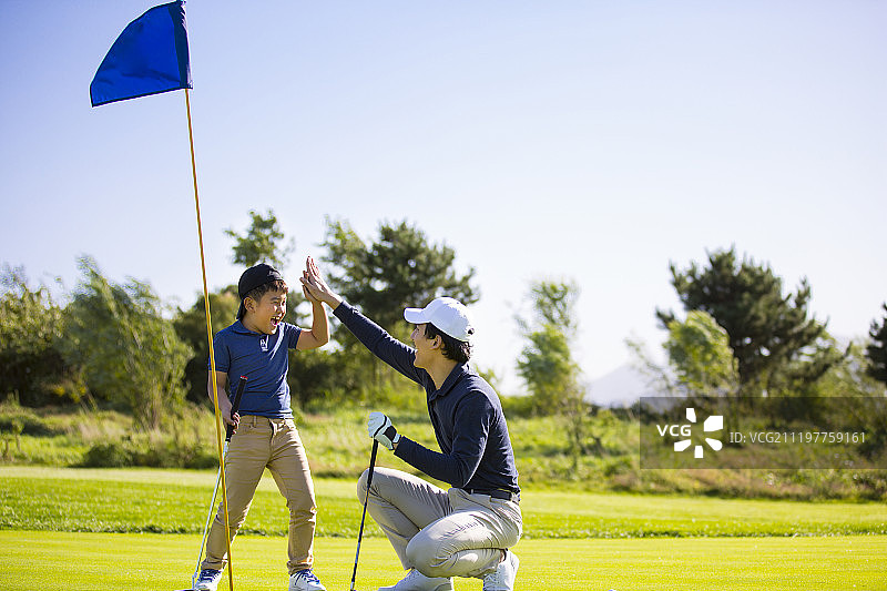 爸爸和儿子打高尔夫球图片素材