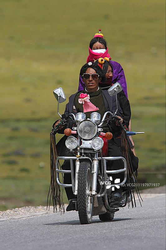藏族群众骑摩托车，位于中国青海省玉树附近图片素材