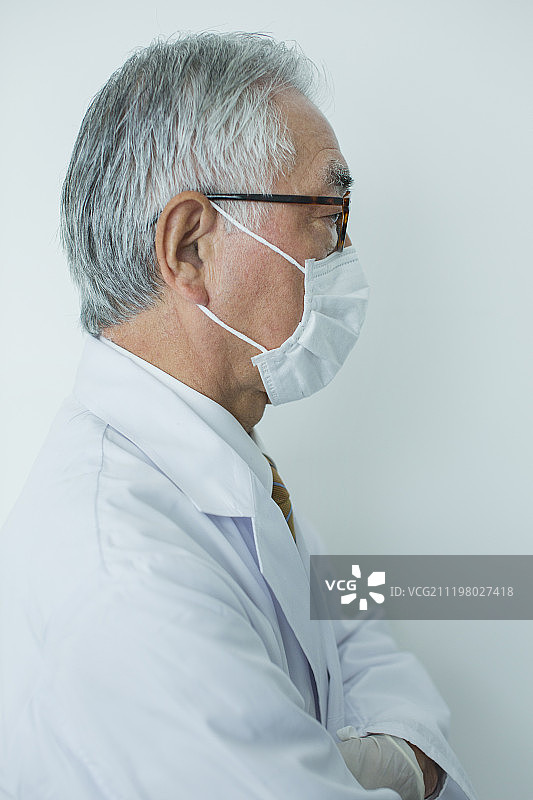 老年男子戴口罩穿白大褂侧视图图片素材