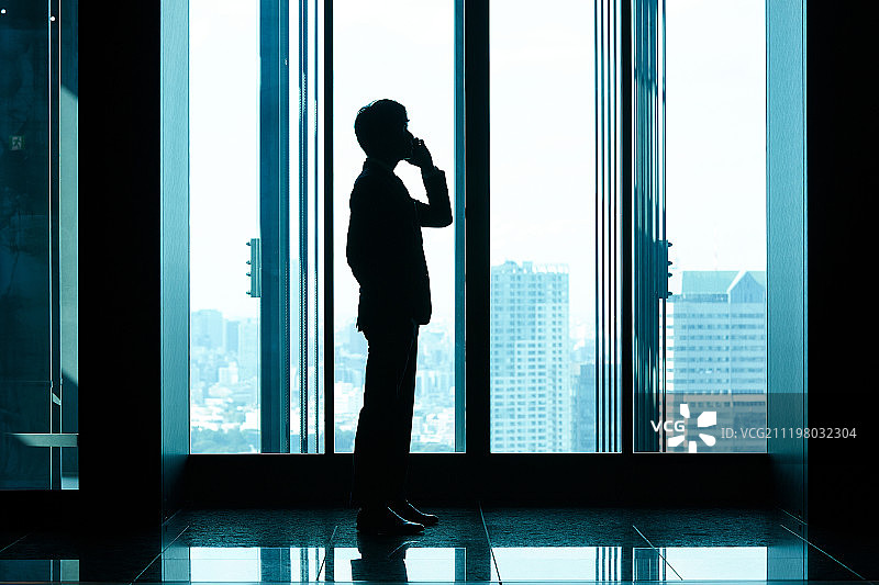 在电梯前使用智能手机交谈的商务人士图片素材