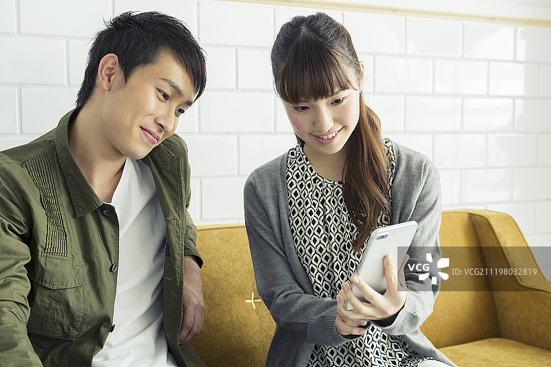 年轻夫妇一起使用智能手机图片素材