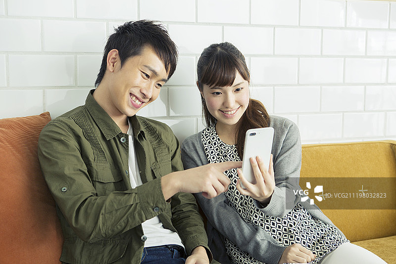年轻夫妇一起使用智能手机图片素材