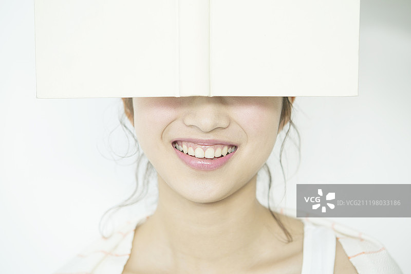 女人用书遮住眼睛图片素材