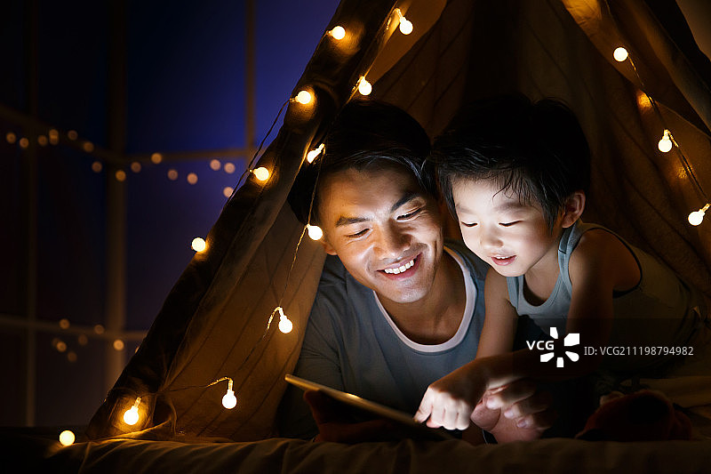 快乐的父子在客厅露营图片素材