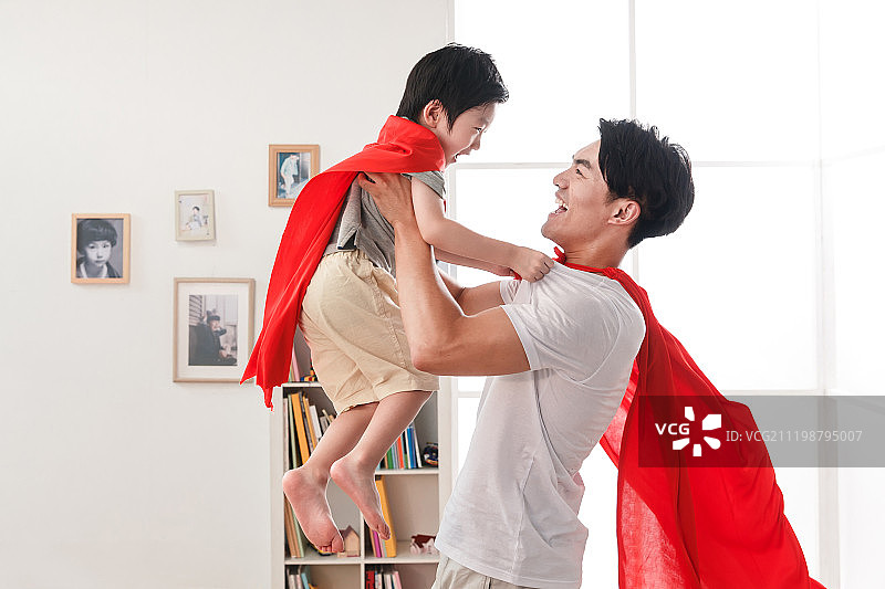 快乐的父子在扮演超人图片素材