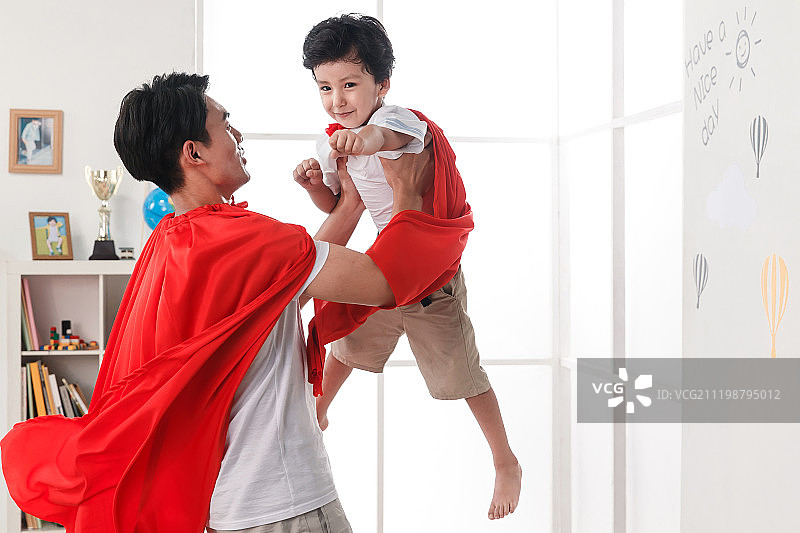 快乐的父子在扮演超人图片素材