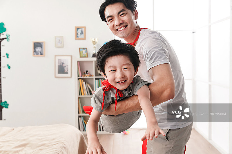 快乐的父子在扮演超人图片素材