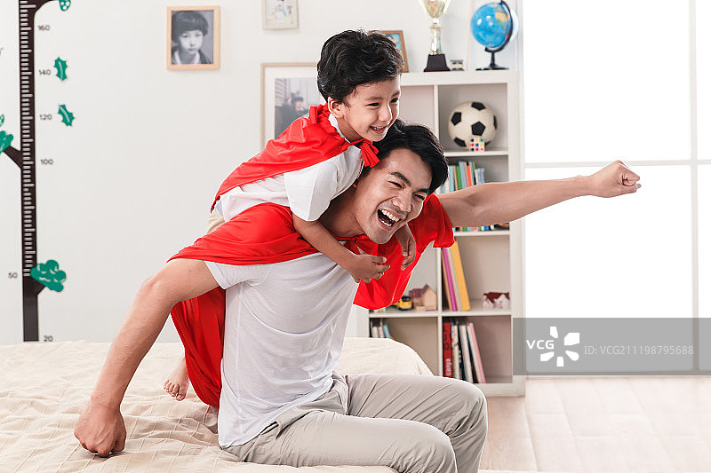 快乐的父子在扮演超人图片素材