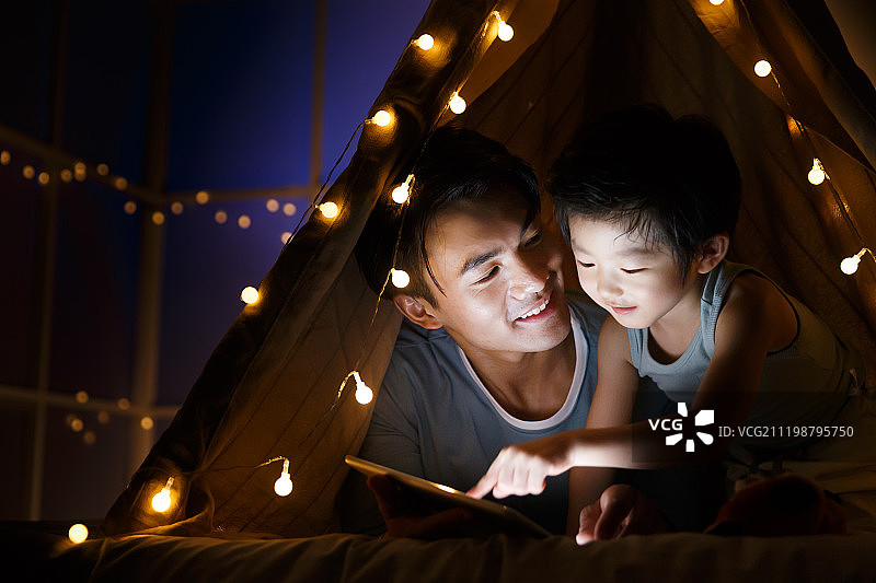 快乐的父子在客厅露营图片素材