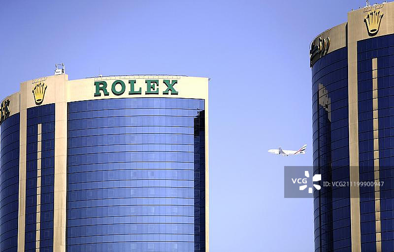 飞机飞过阿拉伯联合酋长国迪拜劳力士双子塔建筑群图片素材