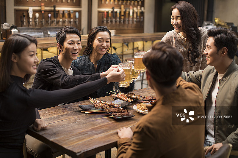 快乐的朋友们在酒吧干杯聊天图片素材