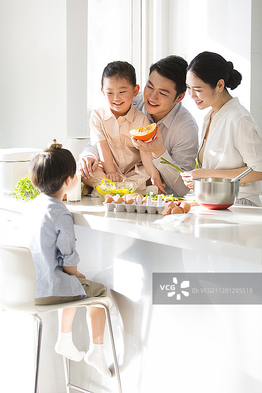 快乐一家四口在厨房做饭图片素材