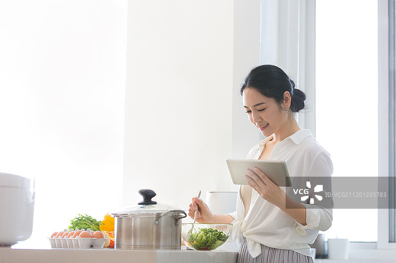 青年女子在厨房做饭图片素材
