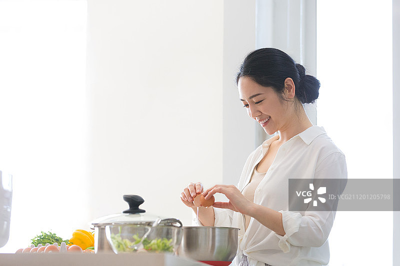 青年女子在厨房做饭图片素材