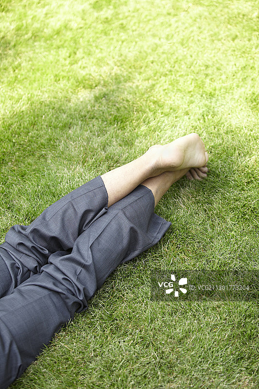商务男士站在草地上的腿部摄影图片素材
