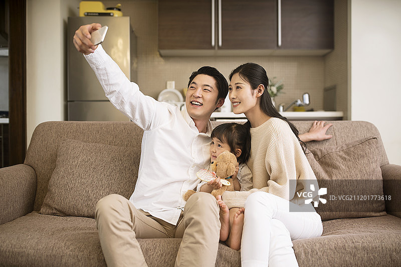 快乐的一家三口用手机自拍图片素材