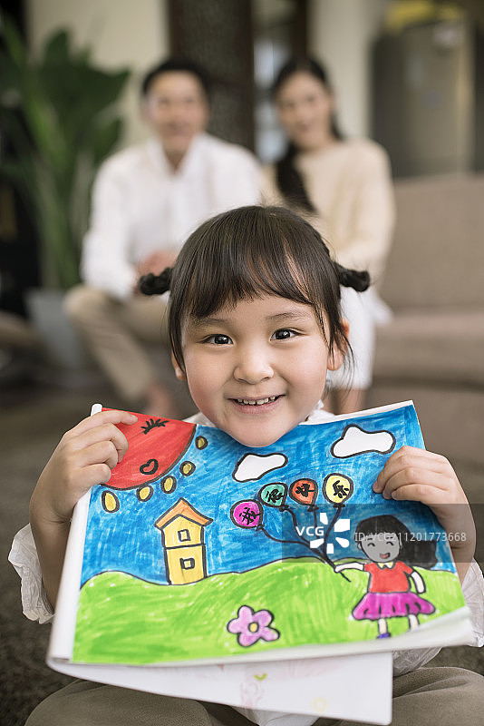 开心的小女孩展示自己画的儿童画图片素材