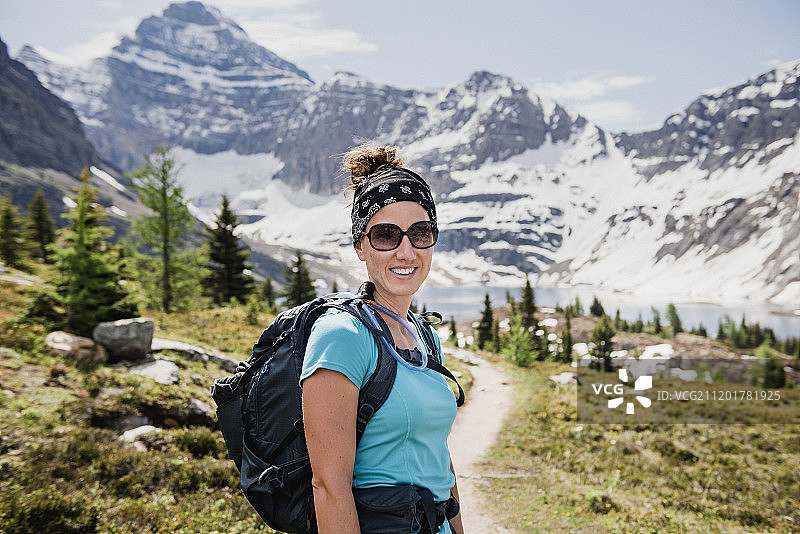 在加拿大不列颠哥伦比亚省幽鹤公园阳光明媚的山路上自信的女徒步旅行者图片素材