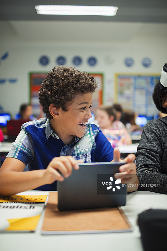 快乐的小学生在教室里使用数位板图片素材