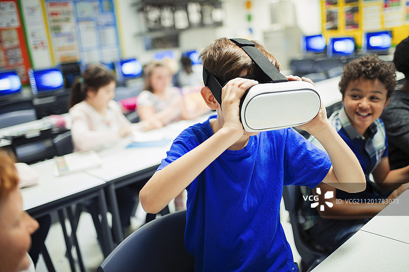 在教室里使用VR模拟眼镜的初中男生图片素材