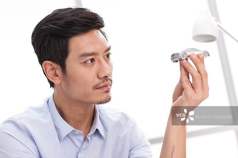 男白领拿着汽车模型图片素材