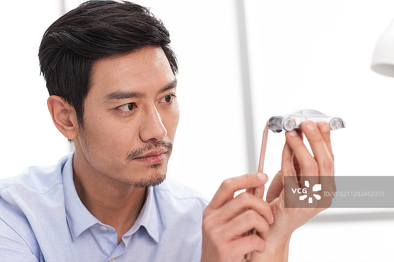 男白领拿着汽车模型图片素材