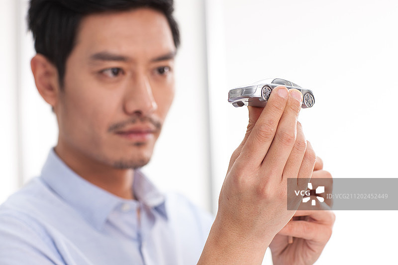 男白领拿着汽车模型图片素材