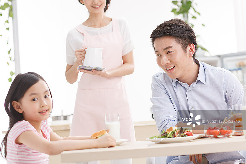 幸福的一家三口在吃早餐图片素材