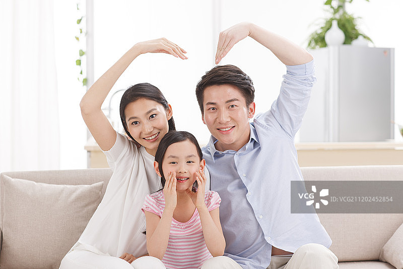 幸福的一家三口坐在客厅的沙发上图片素材