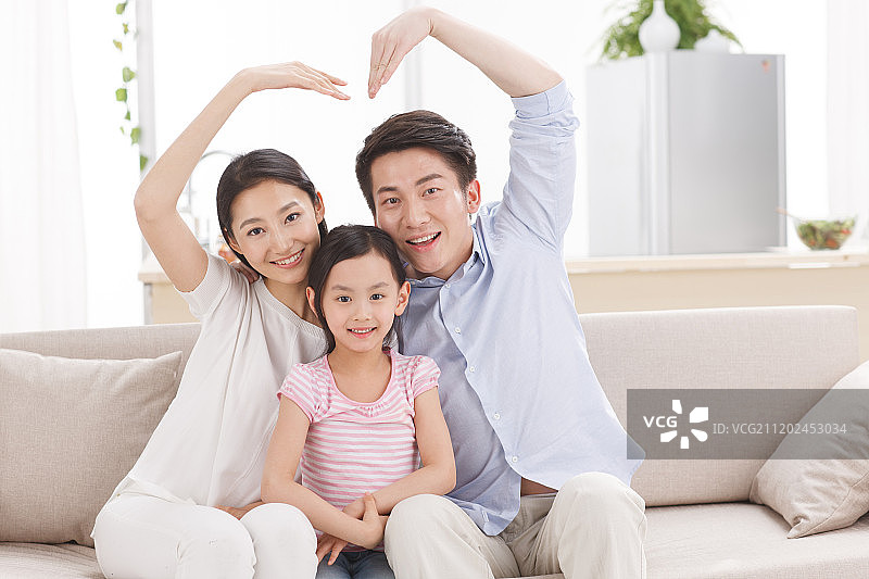 幸福的一家三口坐在客厅的沙发上图片素材
