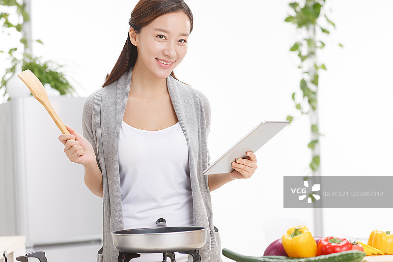 年轻女人在厨房做饭图片素材