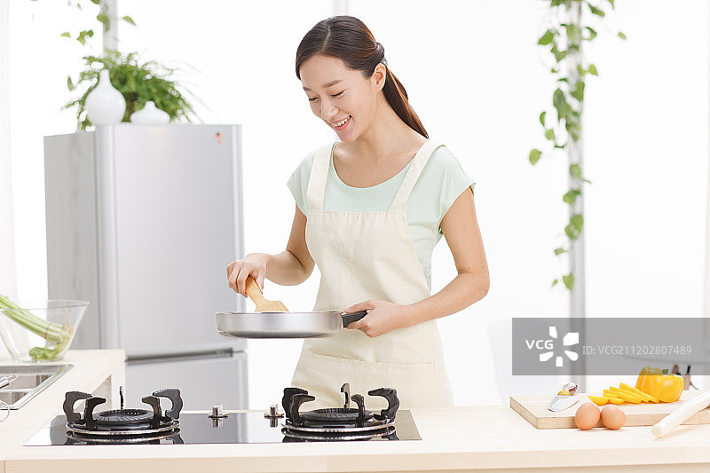 年轻女人在厨房做饭图片素材