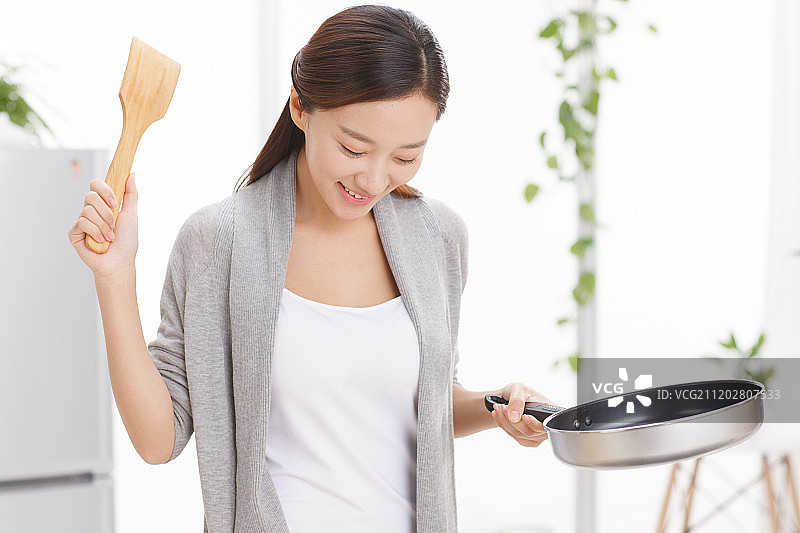 年轻女人在厨房做饭图片素材