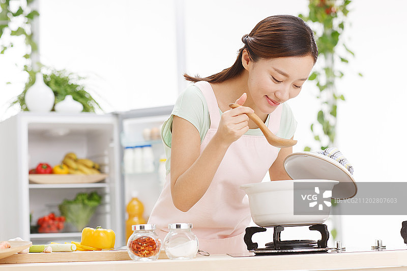 年轻女人在厨房做饭图片素材