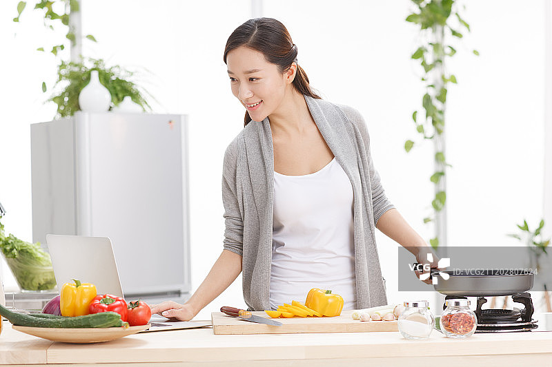 年轻女人在厨房做饭图片素材