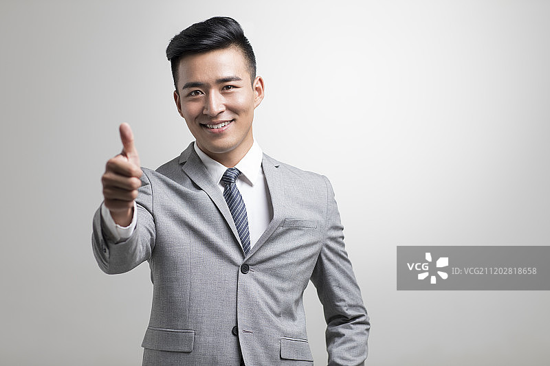 自信的年轻商务男子竖起大拇指图片素材