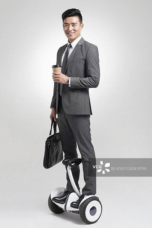 自信的商务男子骑平衡车上班图片素材